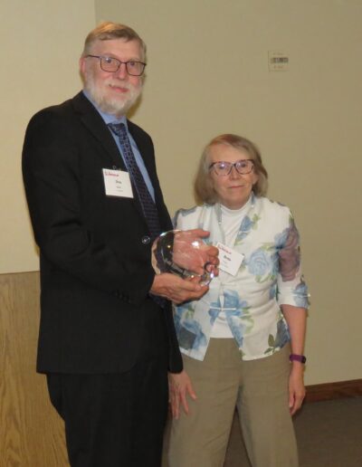 Don Batie accepting Hall of Fame Award for the late Barb Batie from Bette Pore